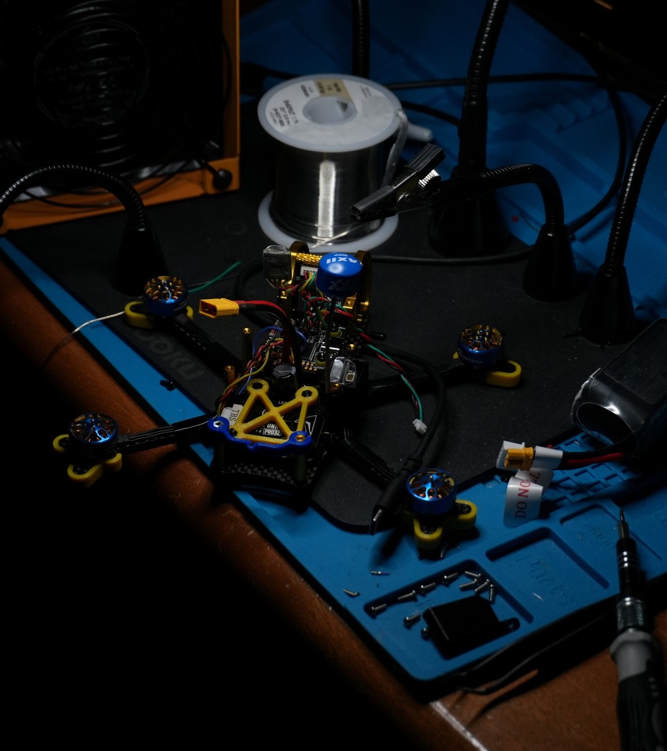 A custom FPV drone under construction on Peter's electronics workbench